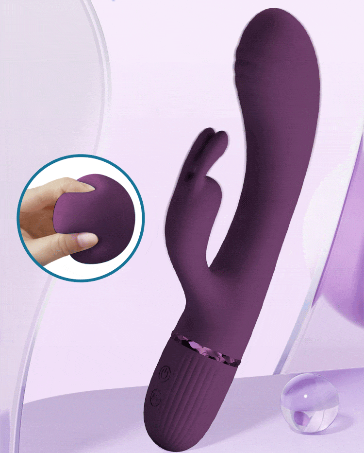 Scocco G-spot rabbit vibrator in purple with a fingertip pressing into its super soft silicone head