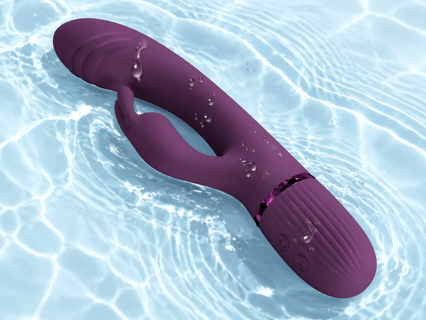 Scocco G-spot rabbit vibrator in purple with water droplets on its body against rippling water