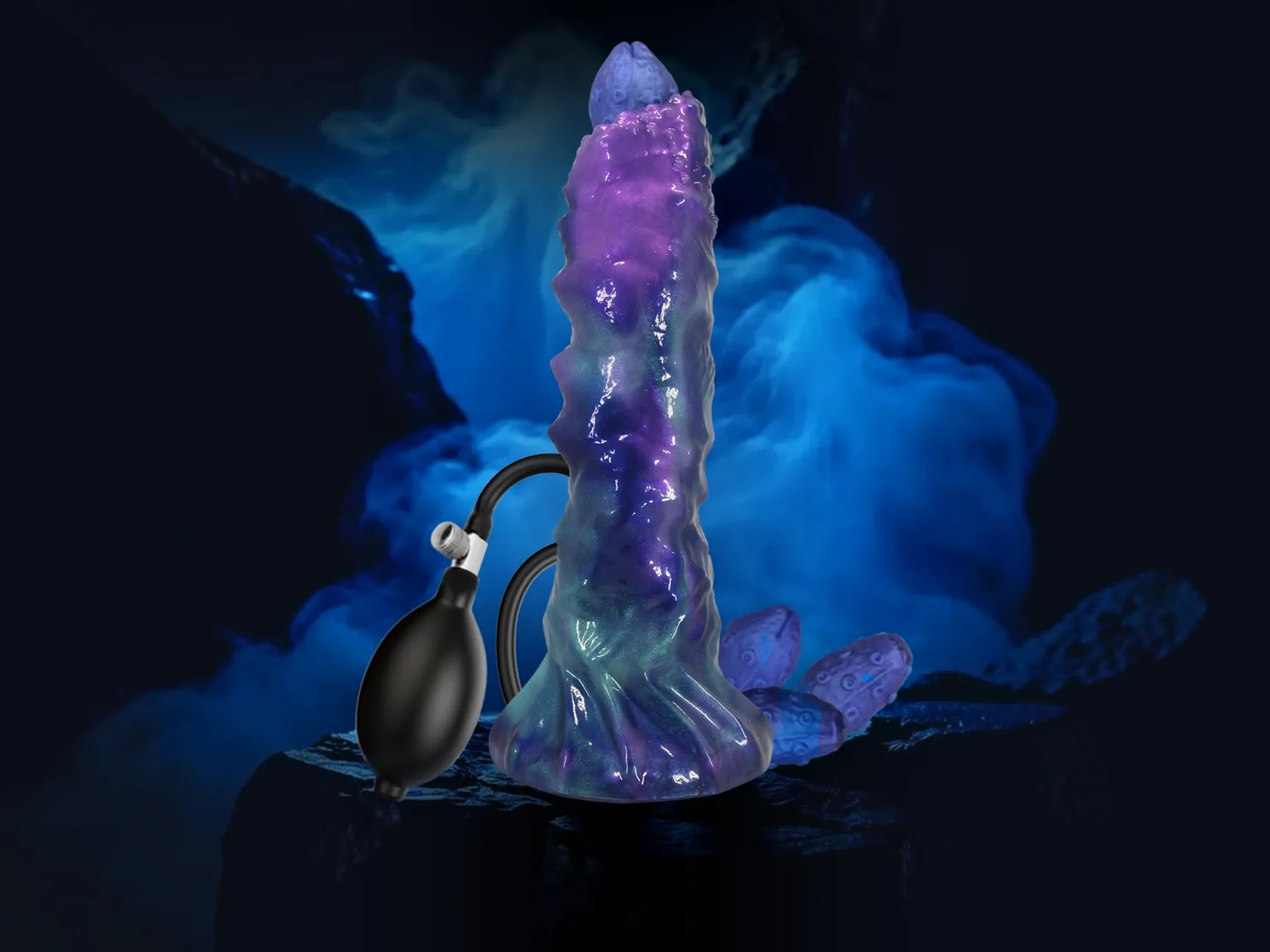 Body-safe silicone monster dildo standing upright with its hand pump and silicone eggs beside it