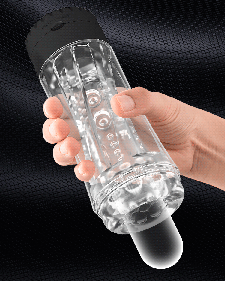 Hand holding a clear vibrating masturbator cup, showing its one-handed grip and size